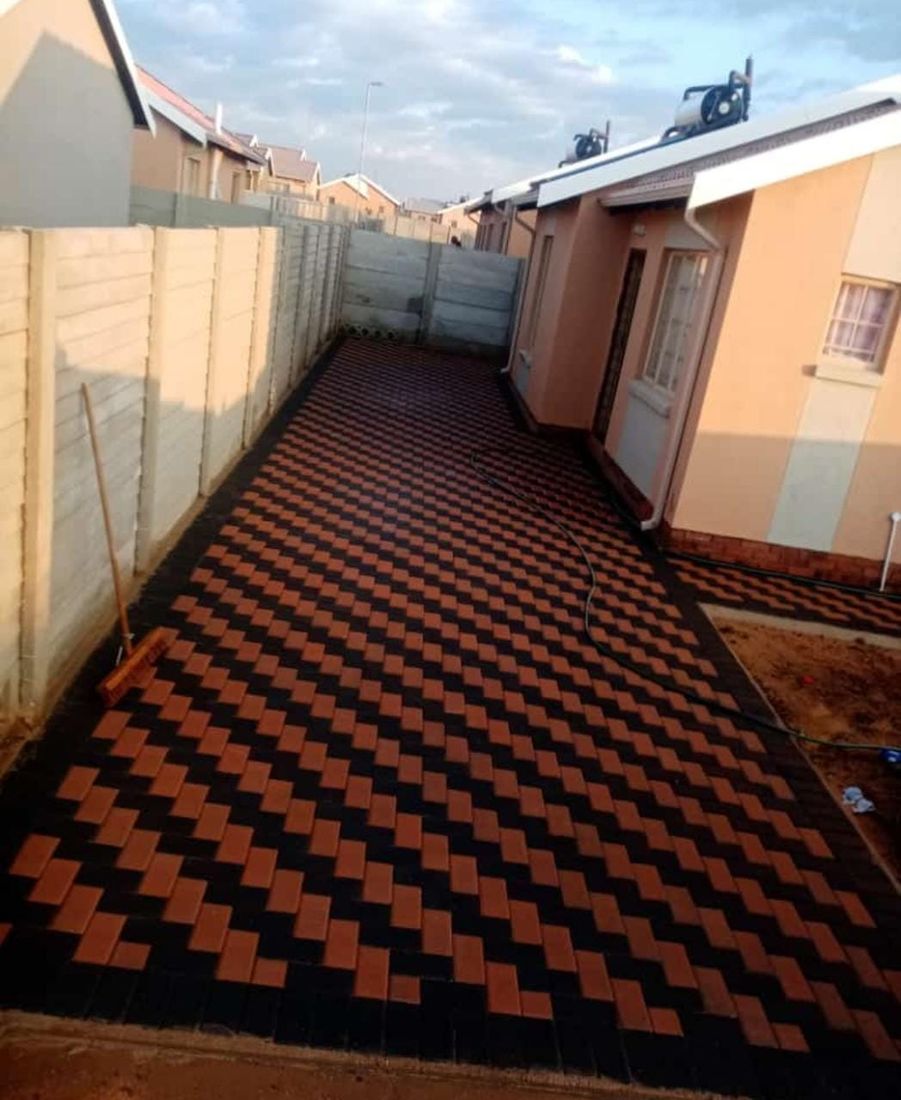 Dramatic black and red herringbone pattern decorative concrete courtyard walkway between houses