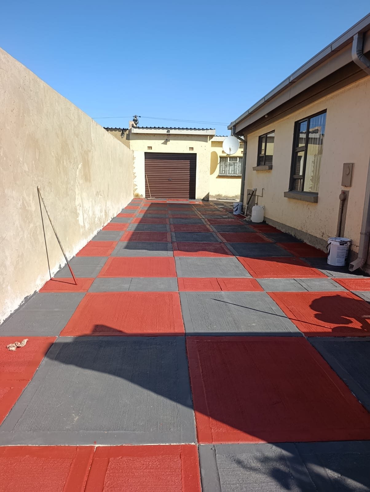 Bold red, charcoal and grey checkerboard decorative concrete driveway installed by Jimmalo Styles Construction